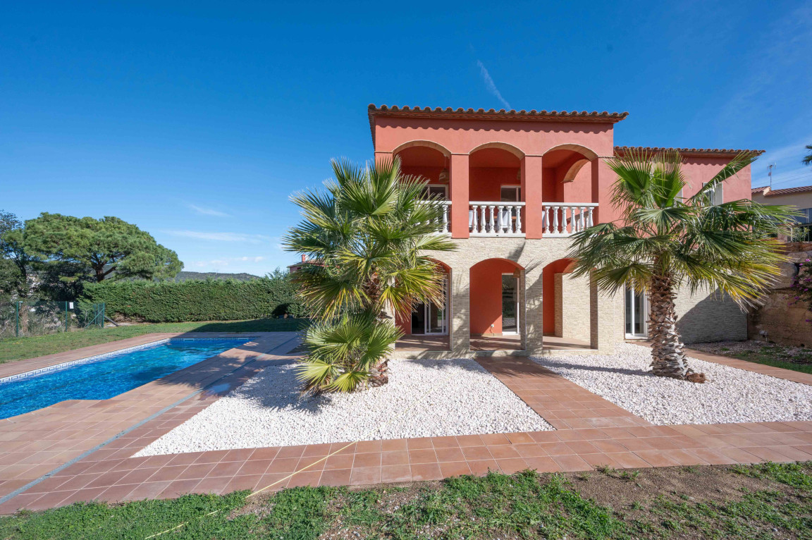 Façade with arched openings with swimming pool and pebble terrace.