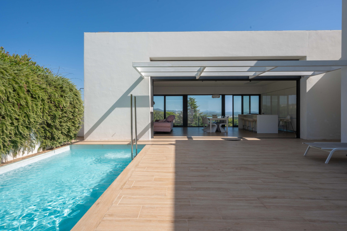 Terrace with swimming pool of a modern house with a view to the sea.